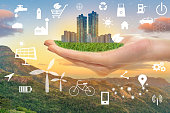 Hand halten grüne Stadt mit ökologischen Ikonen, Erd-Konzept speichern