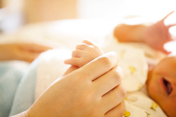 holding hands. hand the newborn baby in the hand of parent. - baby lying down sleeping asian ethnicity imagens e fotografias de stock