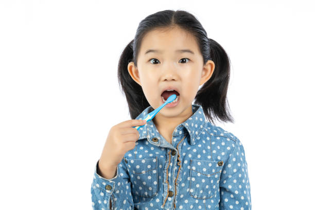 istock Little Girl brushing Teeth on White Background 1275036003