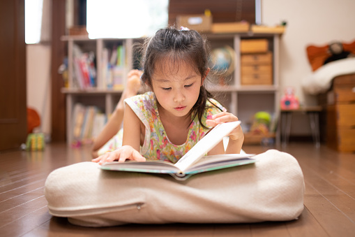 Girl lying down and reading a book