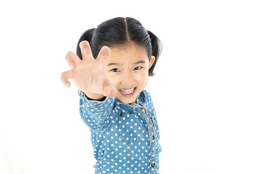 Photo of happy young girl standing isolated over white wall background. Looking camera showing copy space pointing. Concept for adv. Advertisement presenting concept