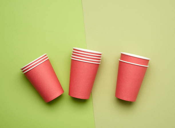 pila di tazze monouso di carta rossa su sfondo blu, lay piatto, concetto ecologico - disposable cup cup stack blue foto e immagini stock