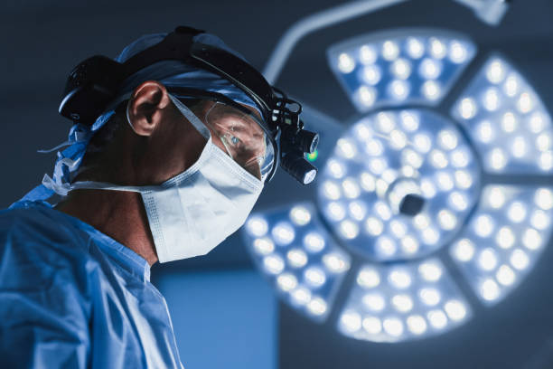 Surgery operation. Senior male surgeon in operating room with surgery equipment stock photo