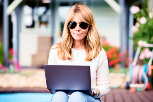 istock Attractive woman using her notebook while sitting in the garden at home 1275071715