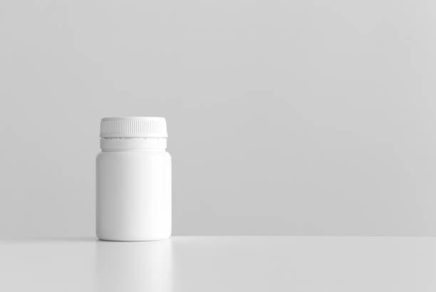 istock White pill bottle mockup with blank copy space on a white table. 1275072853