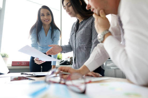 istock Cheerful longhaired brunette talking to her colleagues 1275081358