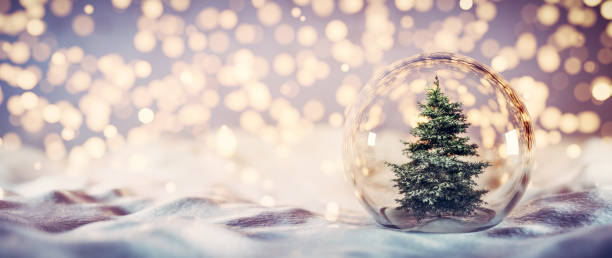 istock Christmas tree in glass ball on snow. Glitter lights 1275082926