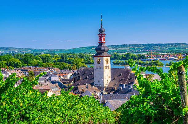 luchtmening van rudesheim am rhein historisch stadscentrum met de spits van de kloktoren van st. jakobus katholieke kerk en de rivier van rijn, blauwe hemelachtergrond, rijnland-palts en de staten van hessen, duitsland - rheingau stockfoto's en -beelden