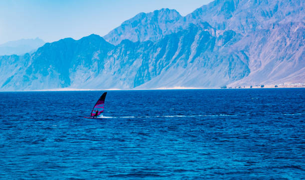 istock Windsurfers sailing in blue open sea 1275084089