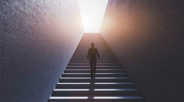 istock Man going upstairs towards light 1275093139