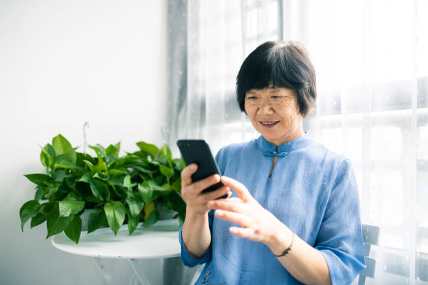 istock Senior woman using a smart phone at home 1275095153