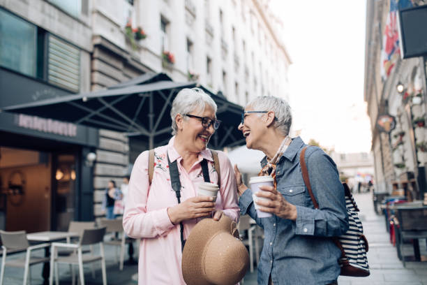 istock Two senior friends on a journey drinking coffee on the move and enjoying 1275106023
