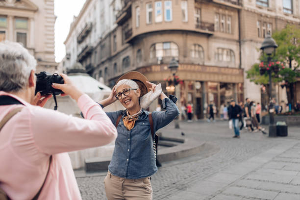 istock Two senior friends on vacation taking photos and having fun 1275106256