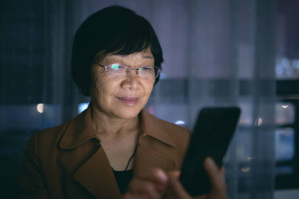 istock Senior woman using smart phone at night 1275114194
