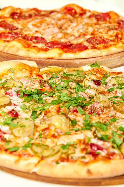 istock Fresh pizza with bacon, pickles and cheese on a light background. Close-up, selective focus 1275125529