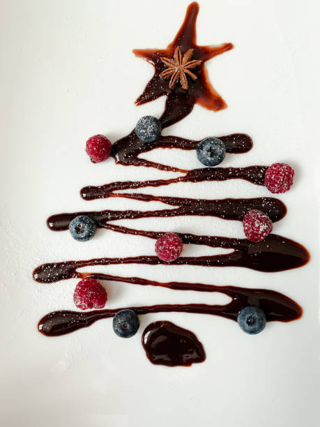 Chocolate Christmas tree with blueberries and raspberries on a white plate