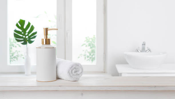 istock Soap dispenser on table against blurred bathroom window background 1275134533