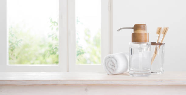 istock Wooden toothbrushes and eccentric soap dispenser against blurred window background 1275135334