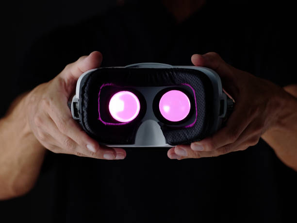 istock Vr glasses in man hands. Gaming device Virtual reality goggles and arm. Dark background. 1275161466