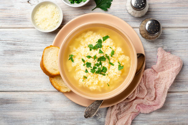 istock Italian stracciatella egg drop soup with parmesan cheese and parsley in bowl on rustic wooden background 1275206573