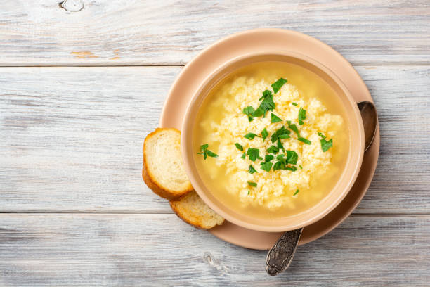 istock Italian stracciatella egg drop soup with parmesan cheese and parsley in bowl on rustic wooden background 1275206581