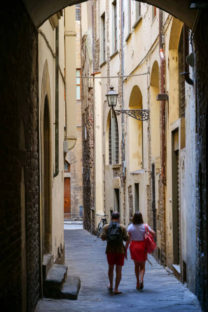 um casal explora um beco típico e antigo no centro histórico de florença - palazzo vecchio piazza della signoria florence italy italy - fotografias e filmes do acervo