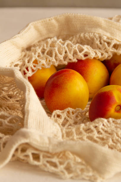 istock Fresh juicy nectarines in a cotton bag on a white background 1275239040