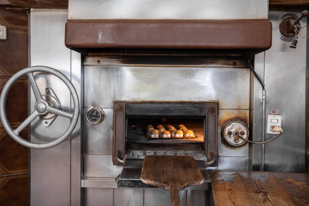 istock Wood-fired oven with door open and cupcakes baking inside 1275246428