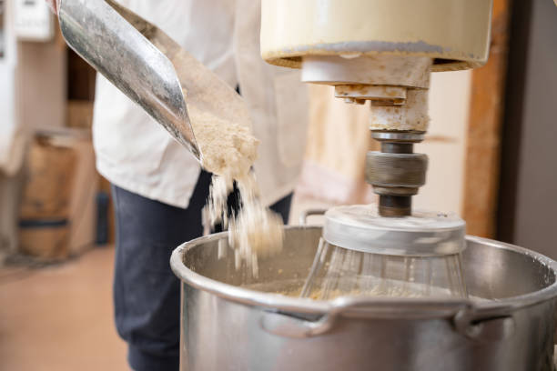 istock Unrecognizable baker woman adding flour into an industrial beater 1275247189
