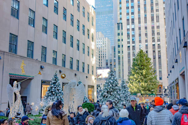 christmas decoration on rockfeller center plaza: angels, christmas tree, ornaments. crowds of people. - rockfeller center imagens e fotografias de stock