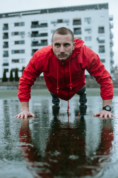 istock Man in red wind jacket is training on rainy day 1275253017