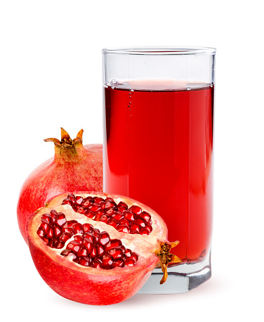 Juice in a glass with pomegranate close-up on a white background. Isolated