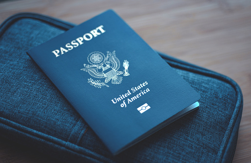 USA (Estados Unidos de América) Pasaporte en cartera de viaje azul, fondo de madera. Vista superior (arriba) photo