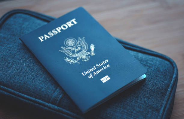 USA (United States of America) Passport on blue travel wallet, wooden background. Top View (above) stock photo