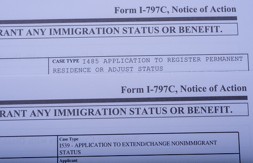 Two Form I - 797C Application to extend change nonimmigrant status (Notice of action, I539, immigration status). Diagonal view.