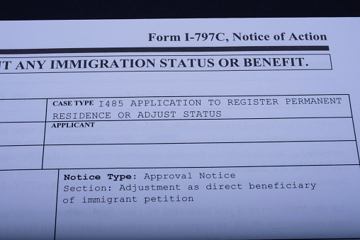Fragment of Immigrant petition Form I-797C, Notice of Action, Case type I 485 Application to register Permanent residence or Adjust status from USCIS. Document on dark blue  background. Close Up.