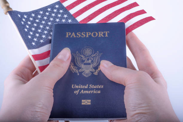 International American Blue Passport and Flag of USA holding in female hands on white background. International American Blue Passport and Flag of USA holding in female hands on white background. Close up. blue us passport cover stock pictures, royalty-free photos & images