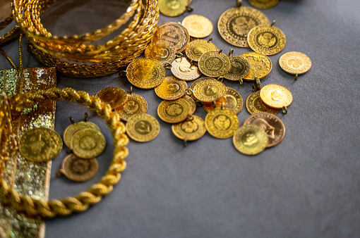 Close-up of gold jewelry and gold coins in the store for sale