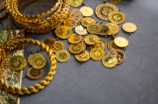 Close-up of gold jewelry and gold coins in the store for sale stock photo
