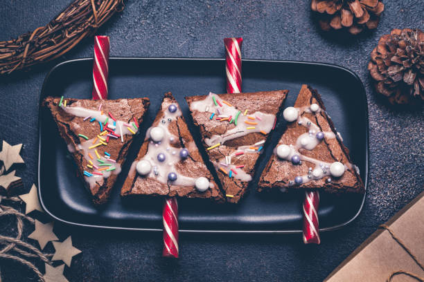 рождественская елка пирожное с леденец и глазурь, темный фон. концепция рождественской еды. - brownie baked bakery brown стоковые фото и изображения