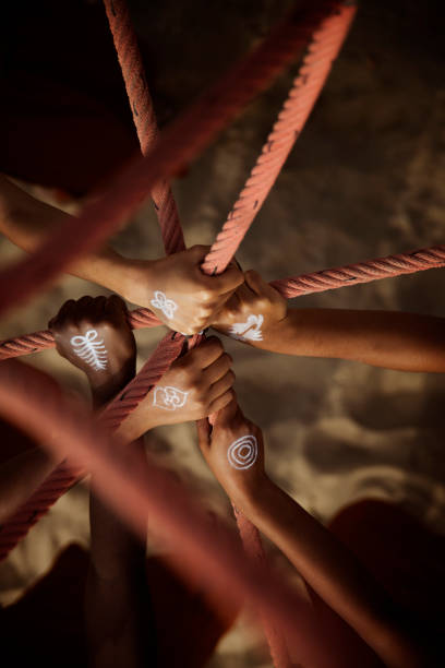 istock Black hands together between rope at the beach 1275297455