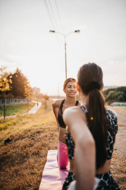 istock Young women perform yoga moves 1275305609