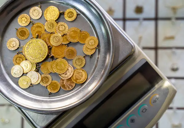 Close-up of gold coins on weighing scale