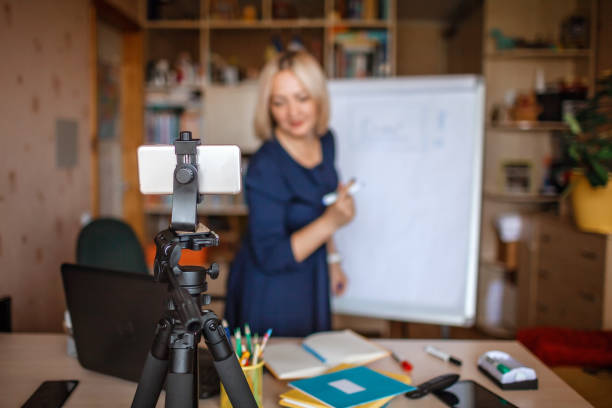 istock Distant education. Middle aged teacher giving online lesson via internet at home 1275310927
