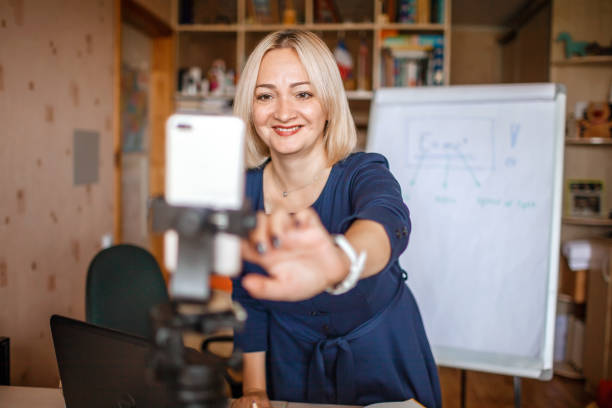 istock Distant education. Middle aged teacher giving online lesson via internet at home 1275311107