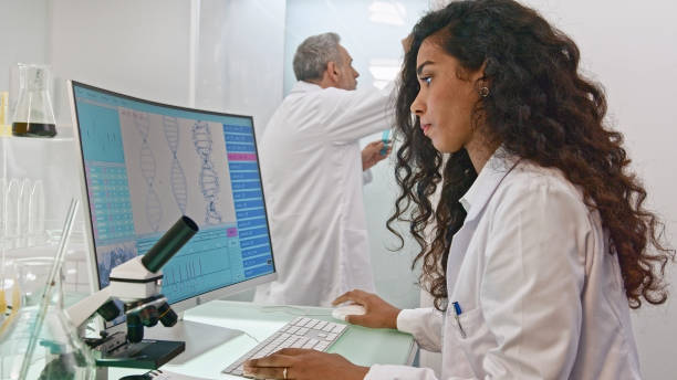 istock Multi ethnic scientists in laboratory. Mixed raced woman in foreground.Brainwave scanning research on computer screens 1275316945