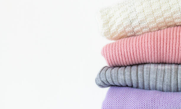 istock Stack of cozy knitted autumn or winter sweaters isolated on white background 1275317094