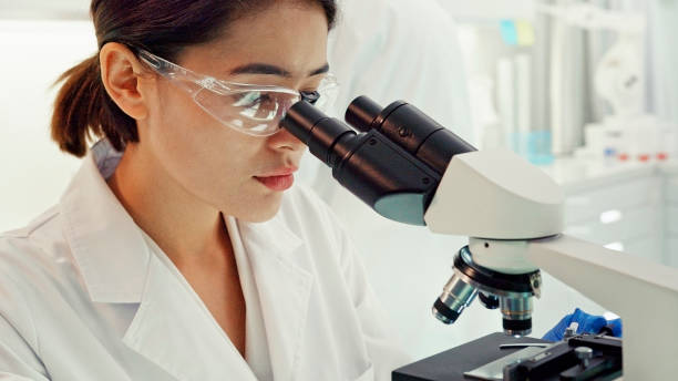 istock Asian female scientist satisfied with her work. Looking through microscope. Futuristic Genetic Research Laboratory 1275317141