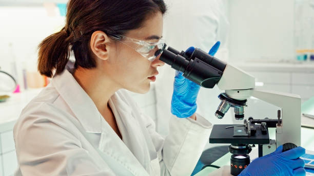 istock Asian female scientist satisfied with her work. Looking through microscope. Futuristic Genetic Research Laboratory 1275317148