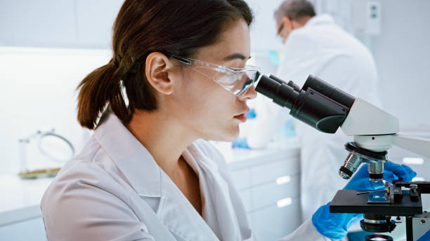 istock Asian female scientist satisfied with her work. Looking through microscope. Futuristic Genetic Research Laboratory 1275317346